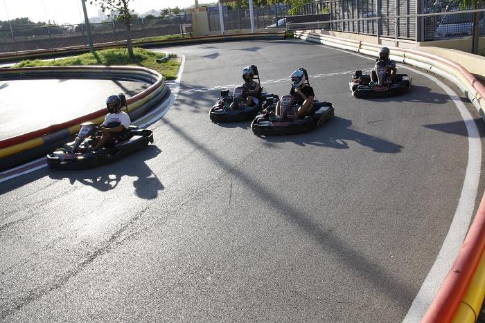 Racers in the gocarts racing around a track.