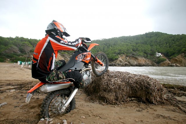 A rider balanced on a log with his bike.