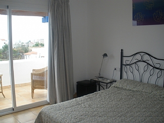 Room with a balcony and a double bed in a rental house of Ibiza